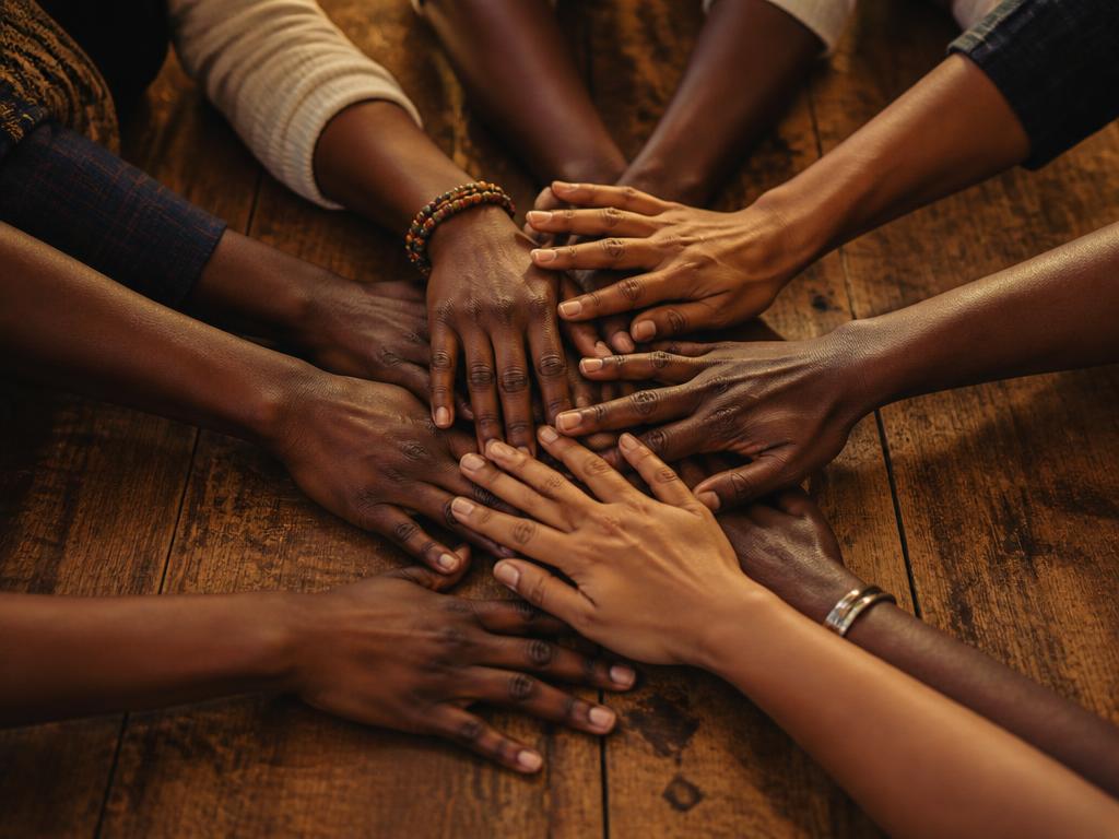 Hands joined together in a circle, symbolising unity and collaboration